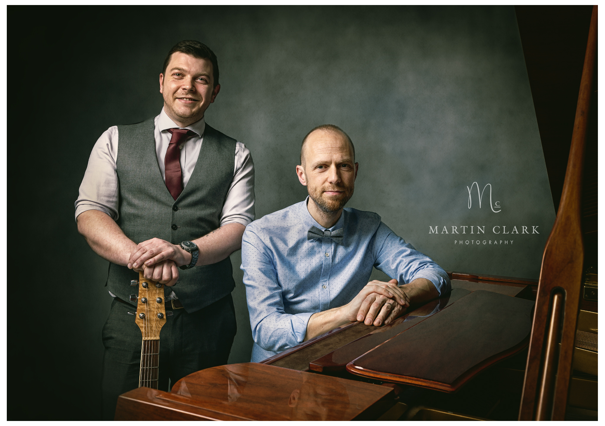 Portrait photograph of two musicians with a piano and guitar