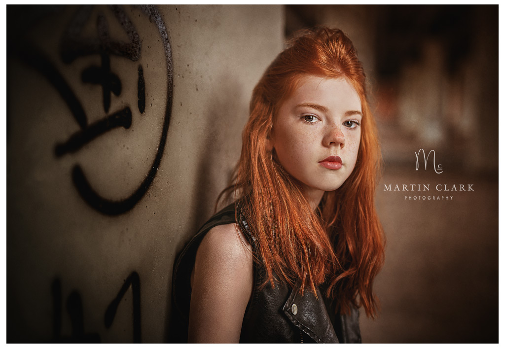 portrait of a teenage girl in an urban underpass red hair