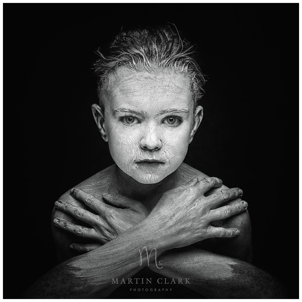 creative portrait of boy with white cracked makeup