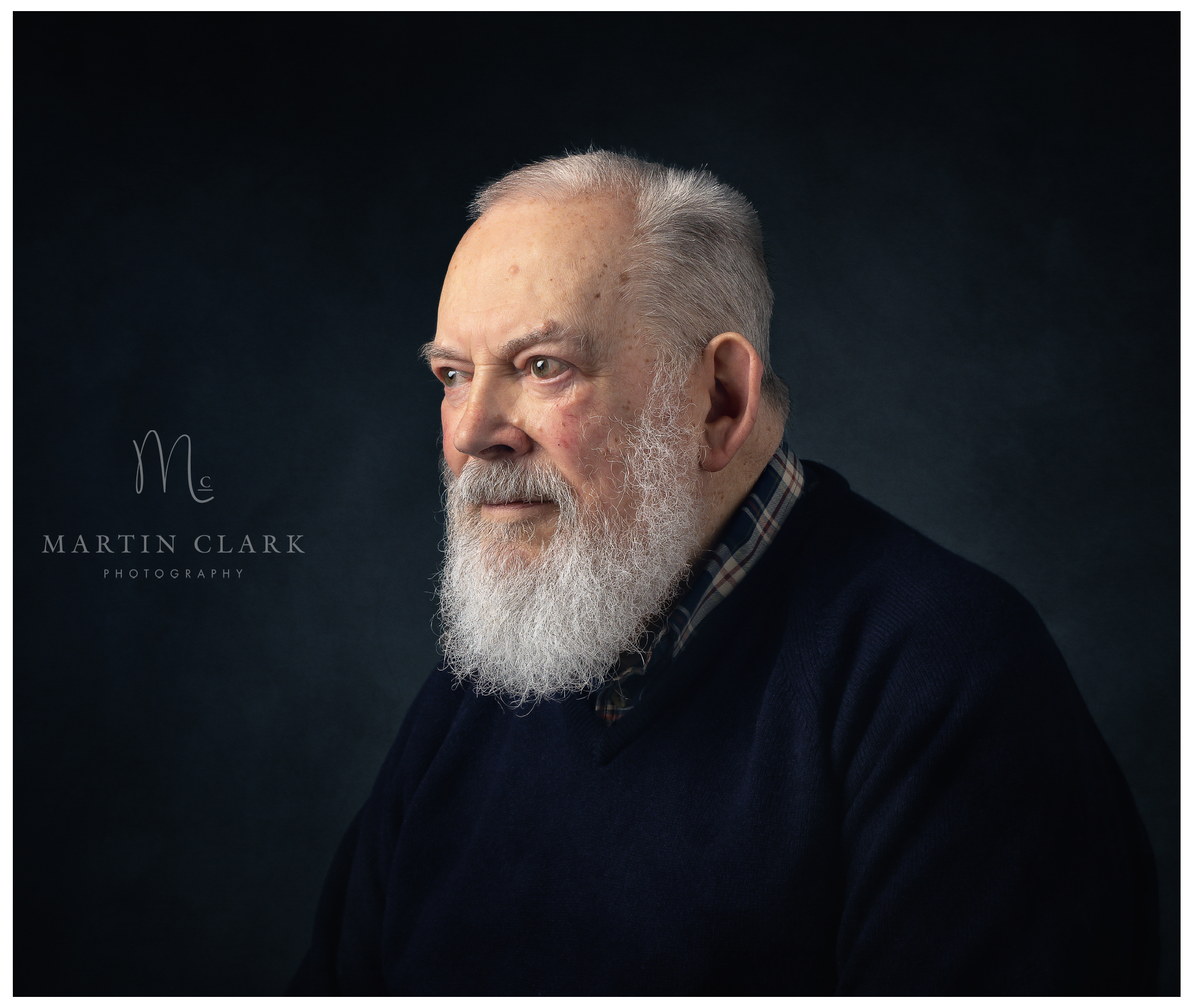 Portrait photograph of an elderly gentleman with silver hair and a long beard