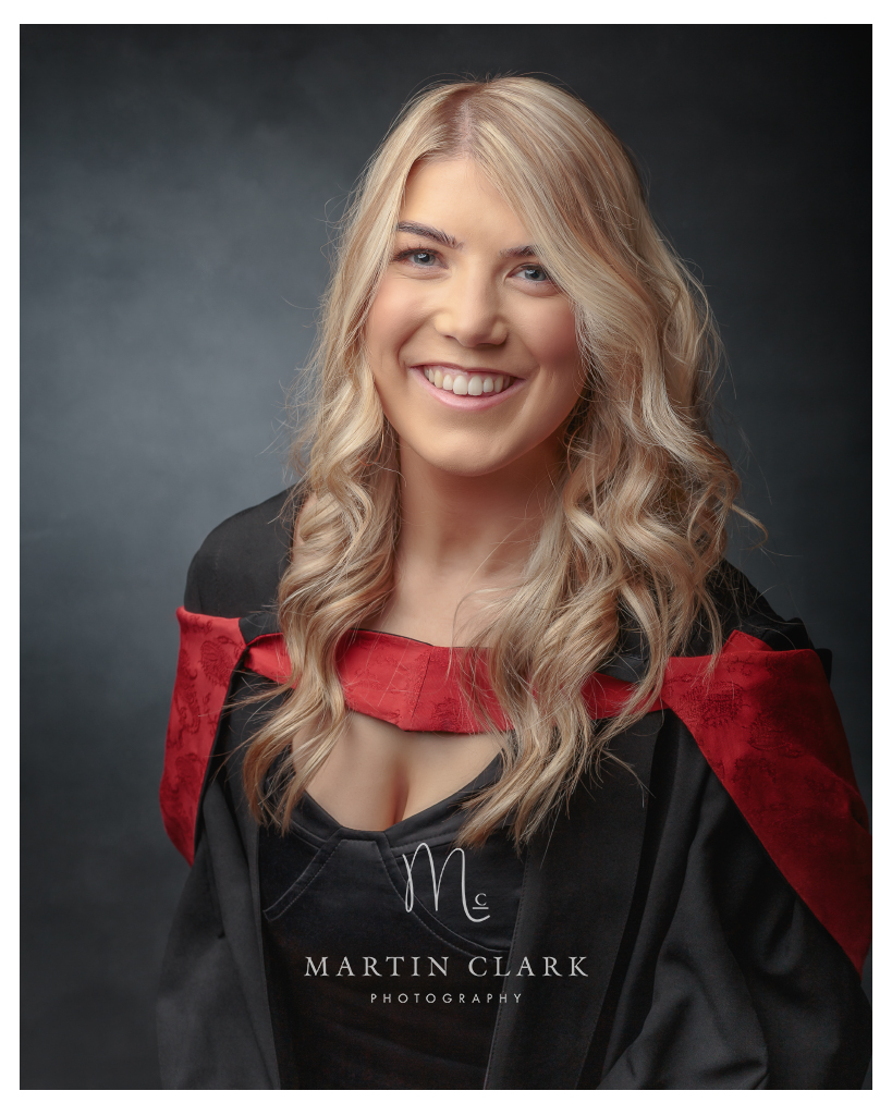 Graduation portrait of young woman with gown