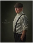 PORTRAIT OF SENIOR MAN STANDING AND WEARING SHIRT AND BRACES AND FLAT CAP