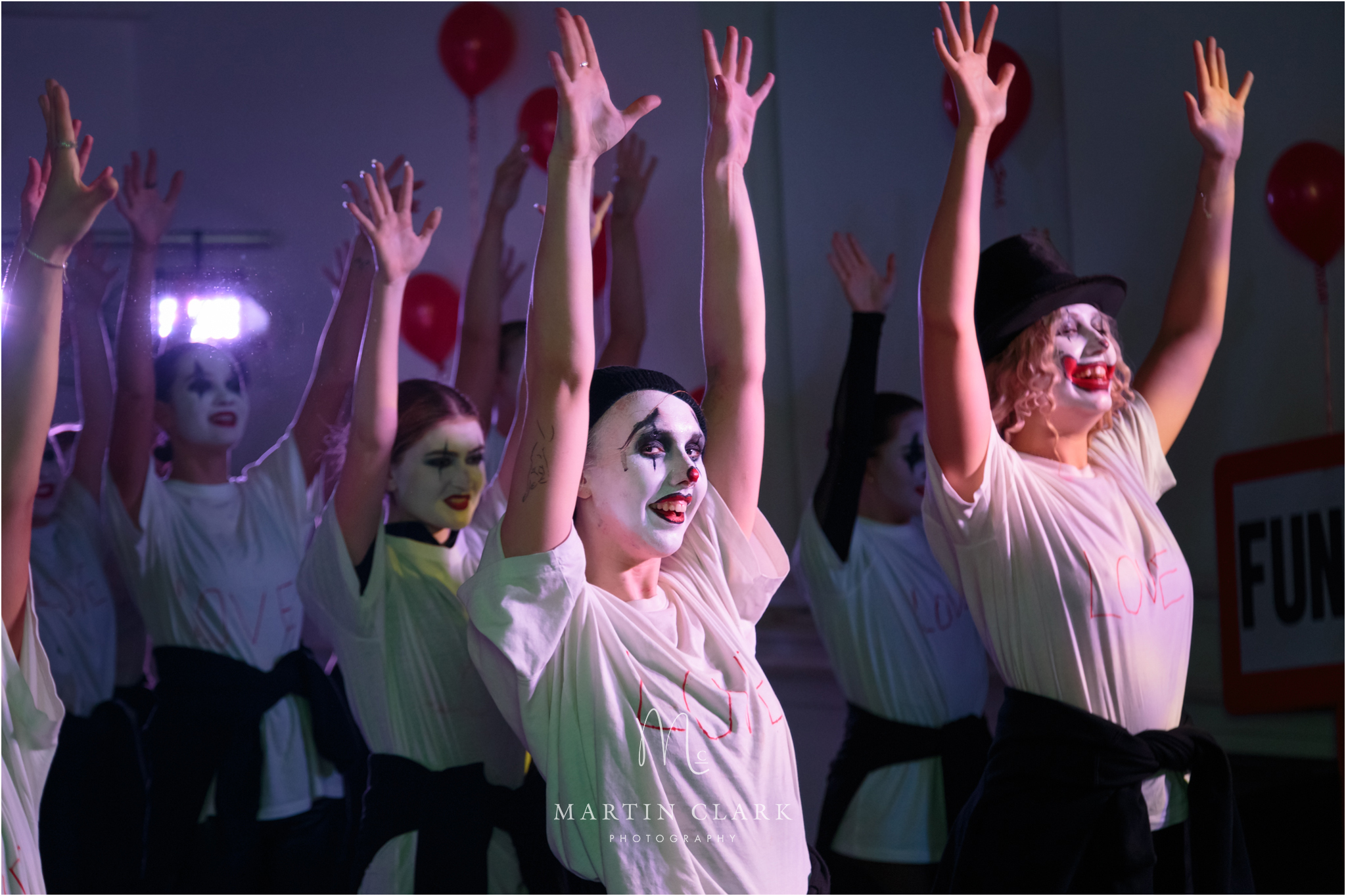 Hamilton Theatre Arts performer with clown makeup dancing in a group
