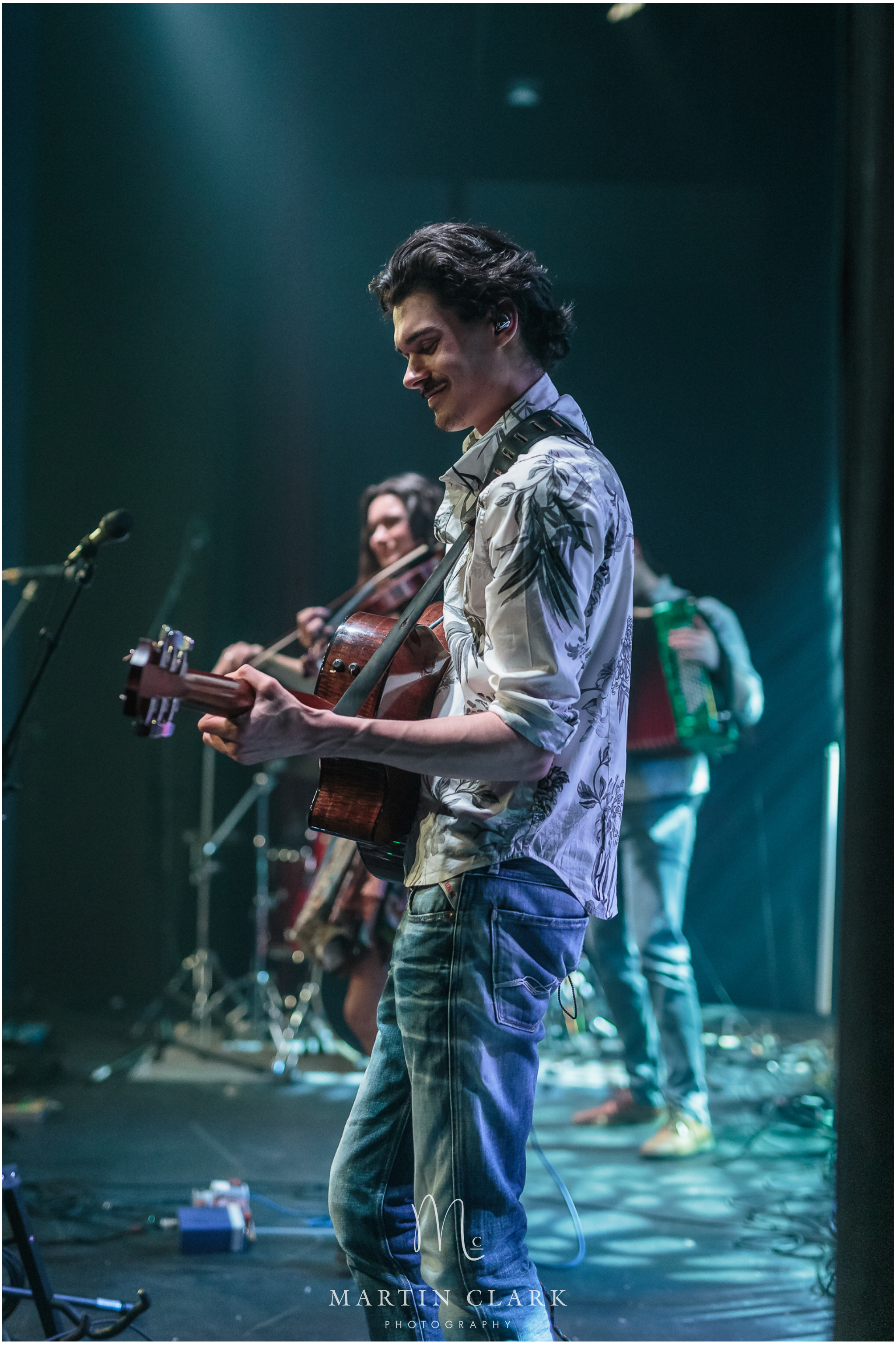 Dinky Blue performing on stage with guitarist in foreground