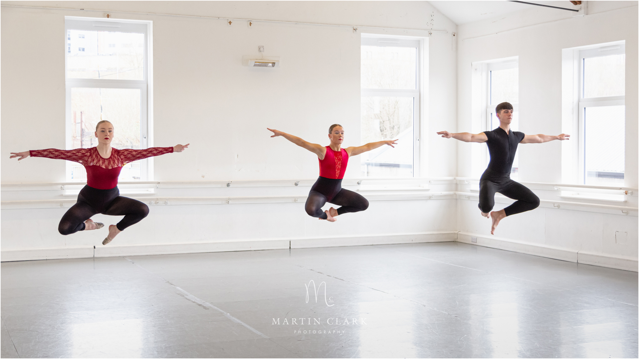 Hamilton Theatre Arts dance performers in mid air position elevated from the dance floor of the studio.