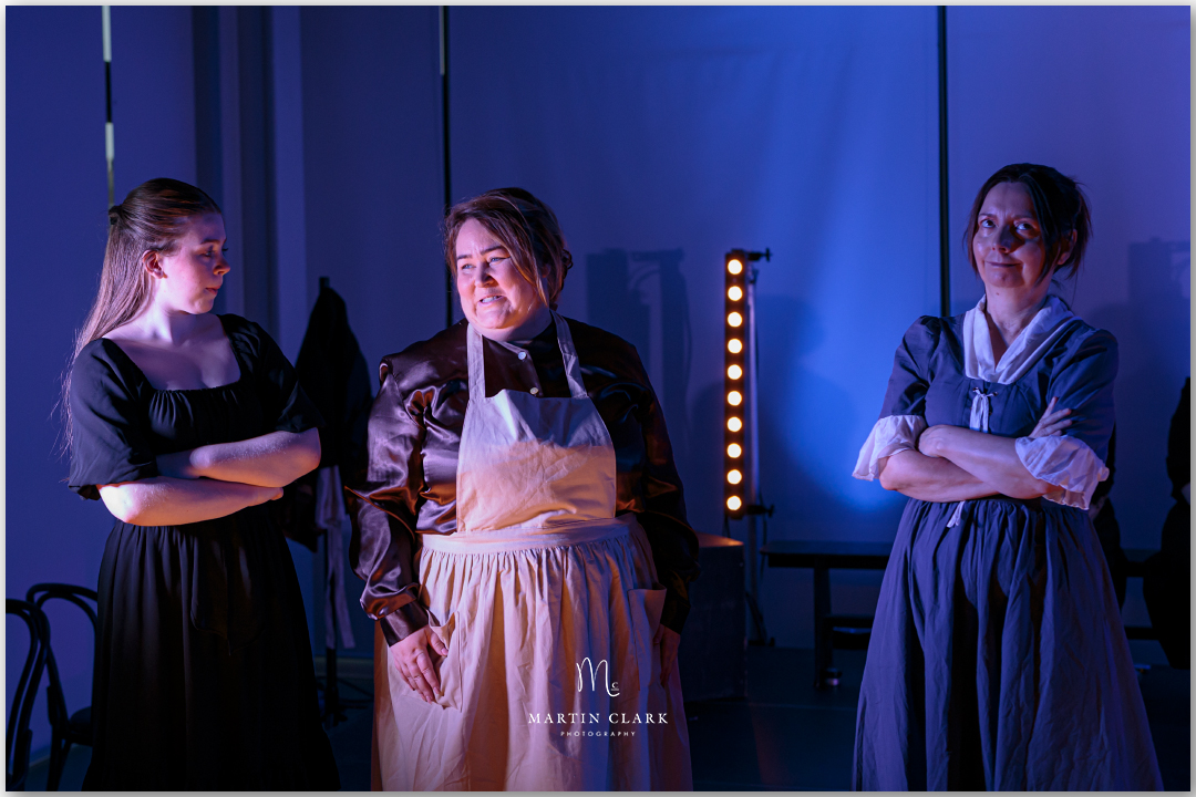 Actresses performing on stage in period drama