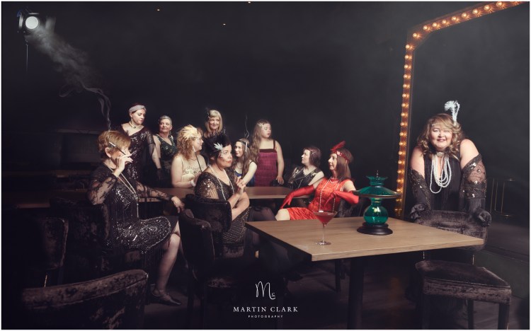 Group of woman dressed in 1920s period costume representing a speakeasy bar scenario during prohibition